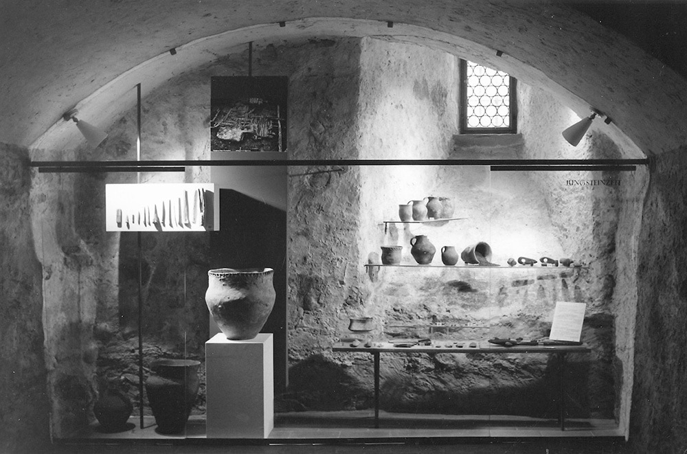 Frontalansicht auf die Ausstellung in den Gemäuern des Schloss Frauenfeld mit verschiedenen Töpfen und Werkzeugen aus der Jungsteinzeit